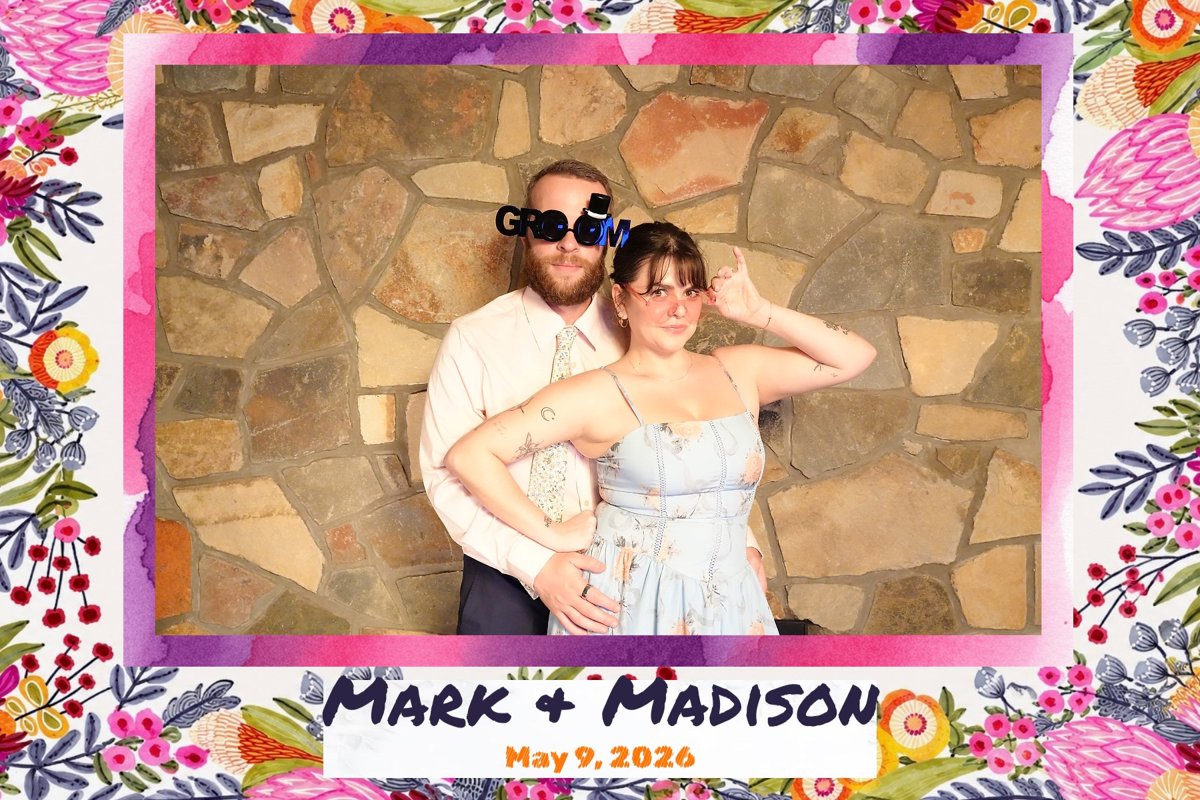 A couple posing with 'groom' glasses, printed with the Mark & Madison photo template.